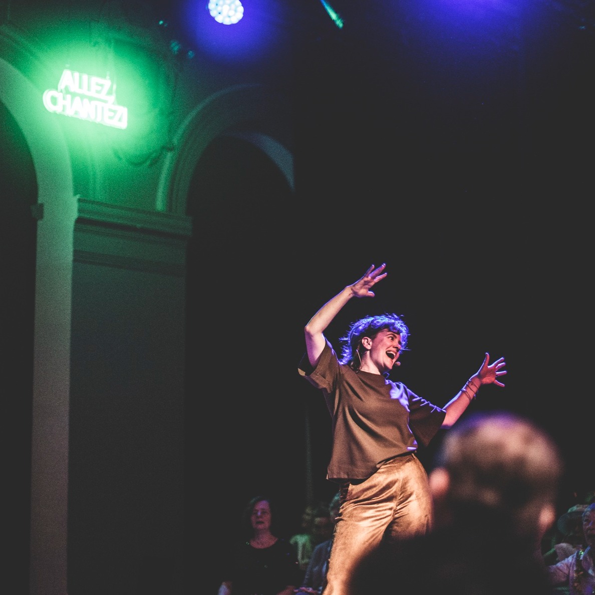 Wat wij voor elkaar betekenen
 
Vandaag stroomt alles voluit in mijn lijf. Een radiator, zo voel ik me. Gloeiend op een stabiele manier. Niet kolkend. Niet bruisend. Wel zoemend. Wolkend. Het hele volume van mijn lichaam is gevuld. De aanleiding voor deze toestand is de zangsessie van gisteren. Vierhonderd mensen kwamen bij @allezchantez samen voor even veel redenen, ieder de zijne. Vooraf wenste ik mezelf toe dat ik me nauw verbonden zou voelen met de zangers en de pianiste. “Ik wil sámen musiceren,” hoorde ik in mijn hoofd. Ik nam ruim de tijd om me mentaal klaar te maken. In mijn stem was souplesse en volheid op te merken. Met zenuwen én vertrouwen stapte ik het podium op. We zongen voluit, met aandacht, met schaterlachen, met flauwe mopjes, met knipogen en hartjeshanden, met zwaaiende armen en wiegende lijven… Ja, we zongen samen. 
 
“Weet jij eigenlijk wel wat je voor al deze mensen betekent? Weet jij wel wat voor verschil jij maakt?” vroeg één van de zangers me achteraf. “Natuurlijk niet,” bracht ik uit terwijl ik mijn hoofd schudde. Ik kan het afleiden uit de moedige respons van zangers die me achteraf aanspreken. Ze vertellen me dat we er in geslaagd zijn om de enige plek te creëren waar zij denken dat zij kunnen zingen. [Serieus, lees die zin nog eens?] Voor iemand anders is Allez, Chantez! de enige plek waar zij even werkelijk alles kan vergeten. Voor nog een ander is Allez, Chantez! de enige plek waar zij zelfliefde kan voelen. … Nee, ik weet niet wat wij voor anderen zijn gaan betekenen. Ik zal het nooit weten. Enkel flarden, snippers. 
 
Maar wat betekenen al die zangers voor mij? En dit project? Voor mij is Allez, Chantez! een plek waar de artiest, onderzoeker en ondernemer in mezelf zich kan ontplooien. Het is de plek waar ook ik in het openbaar kan zingen alsof niemand me hoort. Het is de plek waar ik een heel puur stuk van mezelf op het podium durf tentoonstellen. [lees verder in comments]